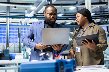 Group of industry experts and engineers analyzing solar panel systems during a production inspection, ensuring engineering accuracy, quality control and factory operations efficiency.