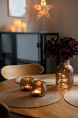 Led lights and interior decor on wooden table in scandinavian room. Hygge life style.