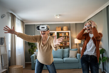 Senior woman playing virtual reality game living room