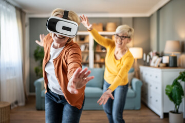 Senior woman experiencing virtual reality with friend enjoying