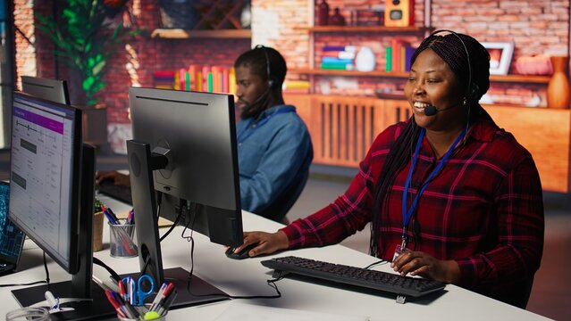 Call center workers track shipments using artificial intelligence, looking at computer screen. Customer center agent uses software to locate clients packages and provide status updates using AI