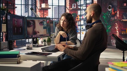 Graphic designer and photographer collaborate in a modern studio, using AI powered photo editing software on PC. Providing automation, retouching and advanced image adjustment tools. Camera A.