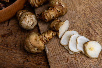 Fresh Sliced Jerusalem Artichokes on Wooden Cutting Board