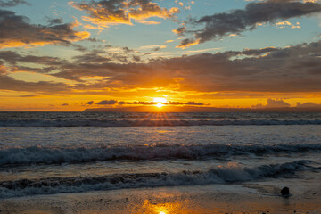 Obraz premium Golden sunset with bright sun over warm sky