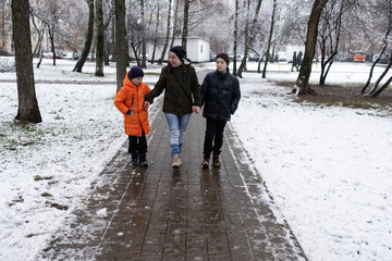 A woman with children on a winter walk. Children's playground with slides and swings
