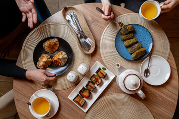 Enjoying a delightful meal with friends at a cozy eatery, featuring dumplings, sushi rolls, and fragrant tea. A perfect blend of flavors and warmth