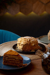 Two exquisite cakes sit on elegant plates, showcasing rich layers and delicate textures in a warm and inviting cafe setting. Soft lighting enhances the treat-filled tablescape