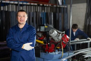 Portrait of male experienced engineer in a robe in workshop of a metallurgical plant