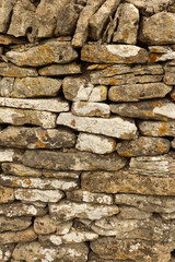 Fototapeta premium Dry stone wall texture showing stacked rocks with lichen and moss growing, ancient construction method