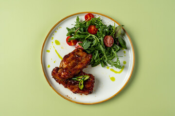 Juicy grilled chicken thighs rest beside a refreshing salad featuring arugula, cherry tomatoes, and a drizzle of olive oil. The bright colors create an appetizing scene