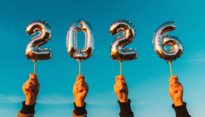 Fototapeta premium Hands holding up silver foil balloons spelling out 