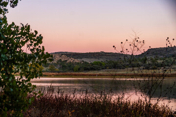 tranquil sunset over placid water landscape, peaceful scene with pastel sky and reflective quiet lake