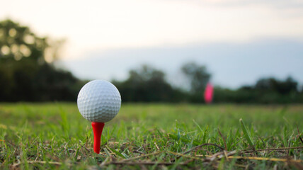 Close-Up View of Golf Ball on Tee Against Sunset Sky Background