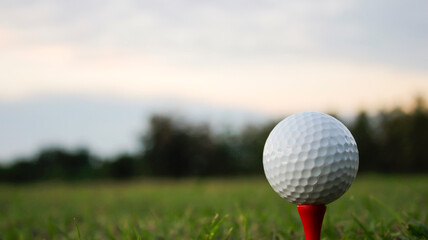 Close-Up of White Golf Ball on Red Tee Against Green Grass Background