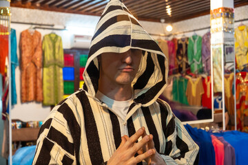 A man is wearing a stylish black and white striped jacket featuring a hood