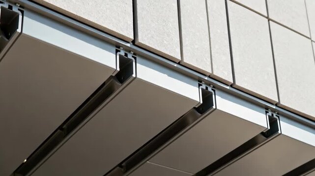 Medium shot capturing the precise alignment of drained rain screen components with integrated channels to direct moisture away from the structure