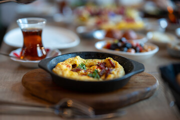 Delicious Omelette in Cast Iron Pan on Wooden Board with Turkish Tea and Breakfast Dishes for Restaurant Menu and Food Photography