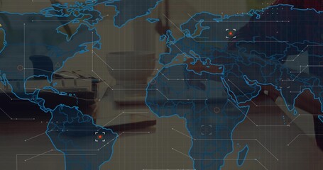 Showing blue map overlay at desk, blurring coworkers in business wear, laptop, notes, mug