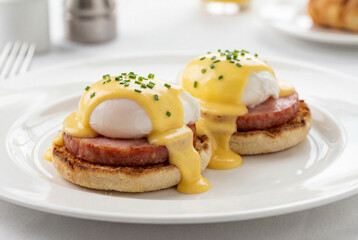 Breakfast eggs benedict with potato pancakes and fried sausage