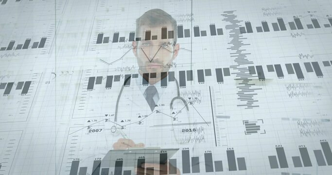 Reviewing physician in white coat and stethoscope holding tablet in clinic, with digital charts - Powered by Adobe
