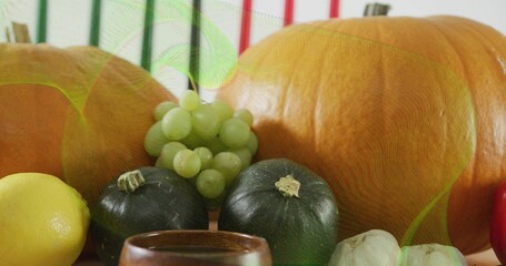 Displaying still-life scene showing two pumpkins and squash on light table with grapes lemon garlic © vectorfusionart