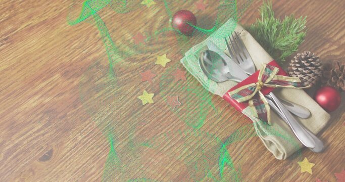 Displaying steel cutlery wrapped in beige napkin with ribbon and pinecone on wood table, copy space
