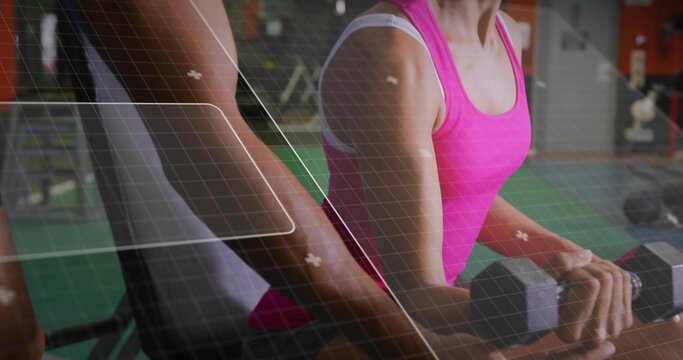 Lifting hex dumbbell, woman pink tank and man black-and-white top working on gym bench, HUD overlay - Powered by Adobe