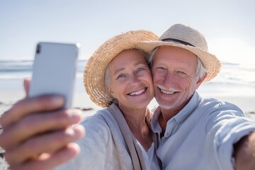 Senior couple taking a selfie with a mobile phone on the beach