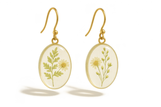 Delicate gold oval earrings with pressed flowers, isolated on transparent background