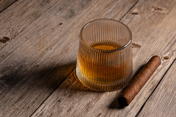Whiskey Tumbler with Cigar on Vintage Wood Background. Classic Cigar and Whiskey Setup on Aged Wooden Table. Luxury Whiskey and Cigar Still Life on Old Wood.