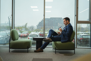 Businessman working on laptop in modern office lounge area