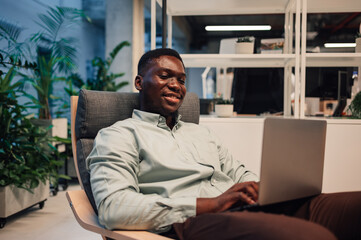 African american man smiling using laptop