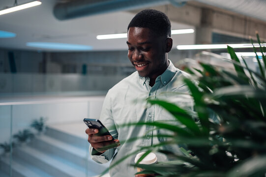 Young black man smiling using phone working