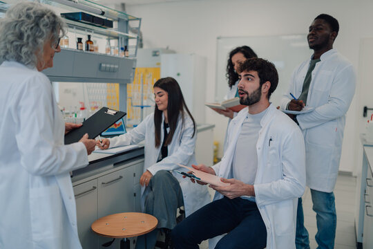 Diverse students collaborating with professor in science laboratory