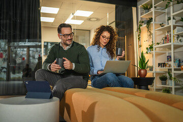 Business colleagues collaborating and discussing ideas in modern office lounge