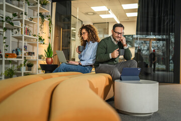 Obraz premium Business colleagues collaborating and discussing ideas in modern office lounge