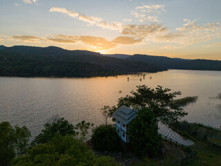 Beautiful aerial shot of Huai Yang Reservoir at sunset, showcasing warm skies, calm water, and peaceful natural scenery.