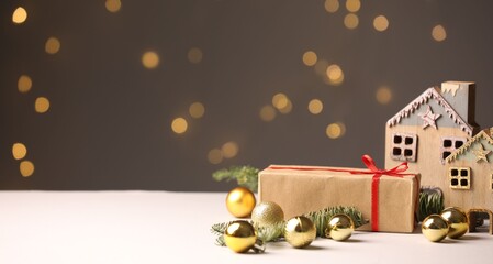 Christmas gift and decor on white table against blurred lights. Space for text
