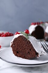 Tasty Christmas cake with cranberries and rosemary served on table against light background, closeup