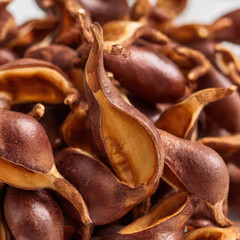Neatly stacked tamarind pods with rustic textures and earthy shades, creating a natural food display. Ideal for tropical fruit markets and healthy ingredient visuals.