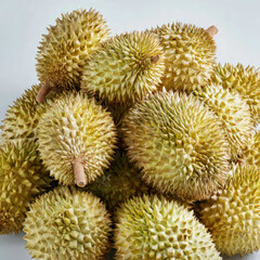 A stack of fresh durians arranged together, showcasing their sharp spikes, natural green tones, and rugged texture. Perfect for tropical fruit themes, market scenes, and Southeast Asian food imagery.