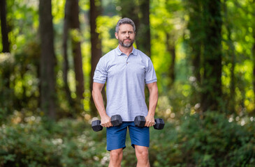 Outdoor workout. Sport athlete man with dumbbell. Healthy lifestyle. Biceps muscle. Strong triceps. Man exercising with dumbbell. Man athlete lifting dumbbell. Strong man do sport exercise