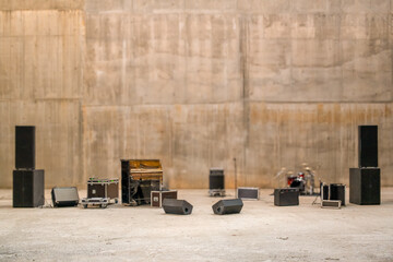 blurred background with musical stage equipment against a concrete wall