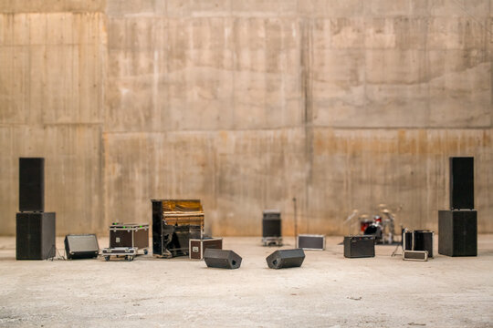 blurred background with musical stage equipment against a concrete wall