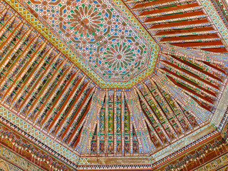 Intricate and Colorful Moroccan Zellige background Ceiling Woodwork with Traditional Geometric Islamic Patterns and Design in a Historic Marrakesh Building