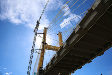Cable-Stayed Bridge Construction with Tower Crane Under Blue Sky