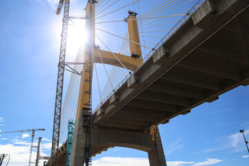 Cable-Stayed Bridge Construction with Tower Crane Under Blue Sky
