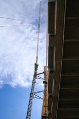 Cable-Stayed Bridge Construction with Tower Crane Under Blue Sky