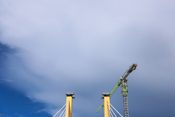 Cable-Stayed Bridge Construction with Tower Crane Under Blue Sky