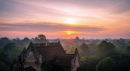 An aerial view of Angkor Wat temple in Cambodia at sunrise, with a misty forest landscape and a colorful sky.